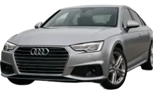 A silver Audi sedan is parked, viewed from the front left side. The car features the signature Audi grille, sleek headlights, and alloy wheels.