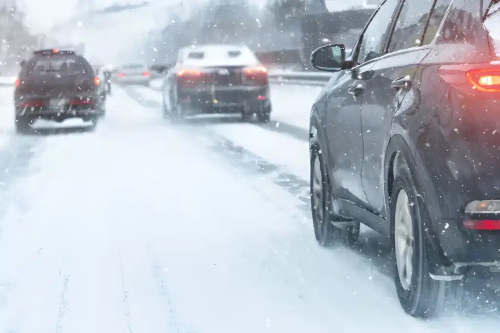 Vehicles driving on a snow-covered road during snowfall