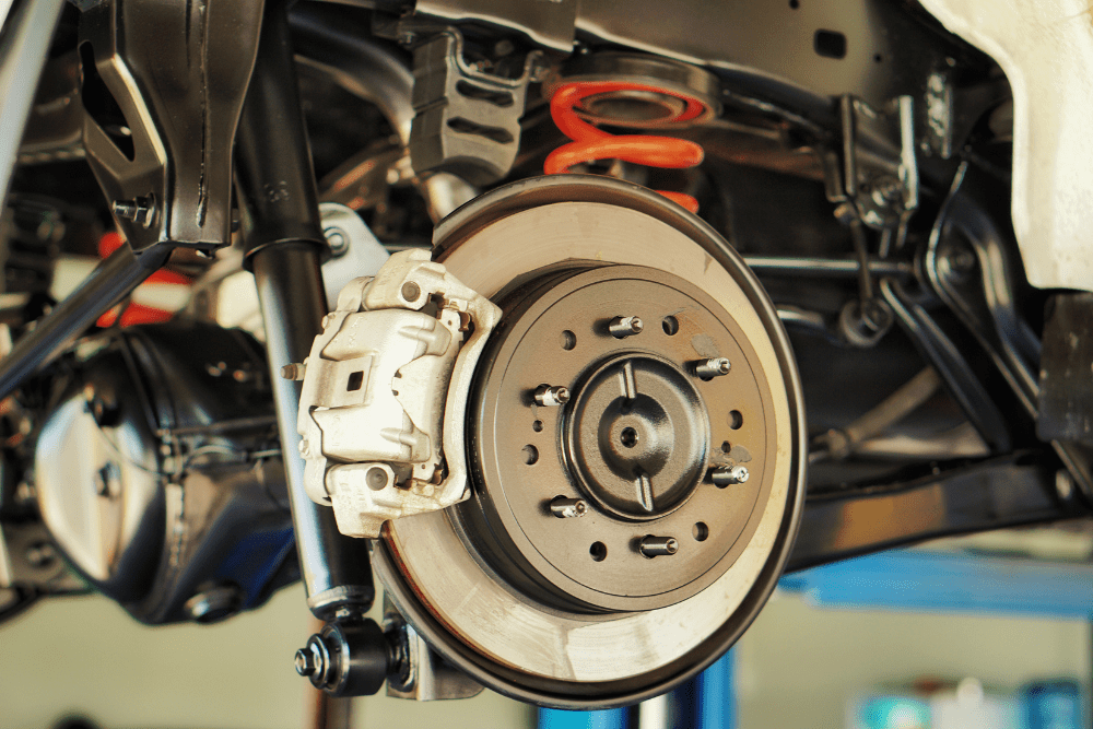 Brake service in Newbury, MA by Angie’s Service Inc. Image of a disc brake system on a lift, highlighting professional inspection and repair for safe stopping.ft, highlighting professional brake service to ensure safe and reliable stopping performance.