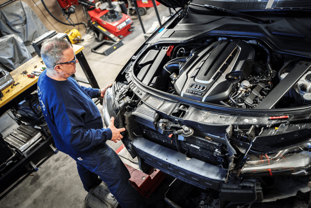 Car inspection, auto repair in Newbury, MA by Angie’s Service Inc. Image of a technician working on an Audi engine, showcasing detailed diagnostics and precision repair to restore performance, reliability, and optimal engine efficiency.