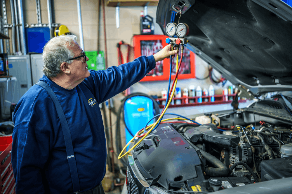 Car maintenance, auto repair in Newbury, MA, at Angie's Service Inc. Image of a technician checking an automotive A/C system with manifold gauges during routine car maintenance, helping optimize vehicle performance, reliability, and year-round driving comfort.